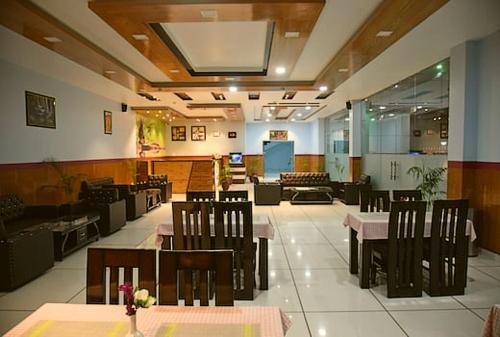 帕拉姆普尔Jai Hotel By Boho的餐厅内带桌椅的用餐室