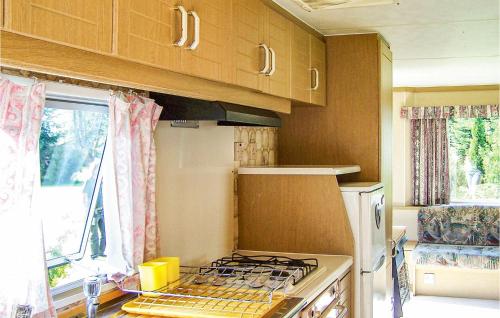 达尔沃沃Lovely stacaravan In Darlowo With Kitchen的一间带炉灶的厨房 窗边的顶部烤箱