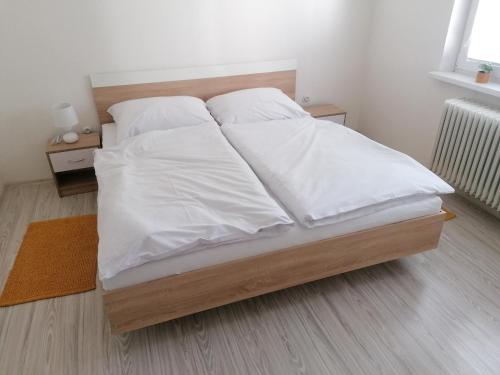 鲁容贝罗克Apartmán RUŽA14的一张带白色床单和枕头的床