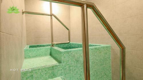 安吉利斯La Grande Residence- Grand Studio的浴室设有绿色瓷砖浴缸及淋浴