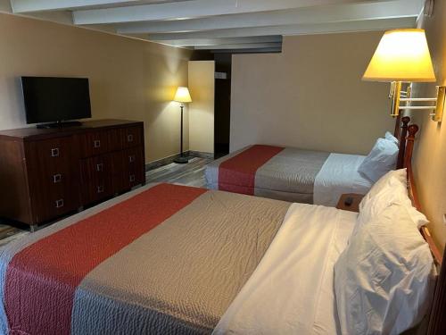 罗克福德Hotel Weston RFD的一间酒店客房,设有两张床和电视