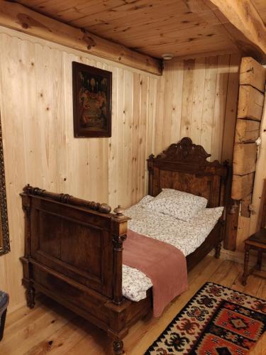 SikoryLetnisko Sikory的卧室配有一张床铺,位于带木墙的房间内