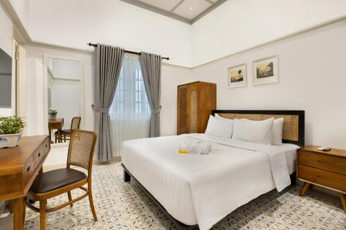 日惹CERIA HOTEL at Alun Alun Yogyakarta的卧室配有一张白色大床和一张书桌