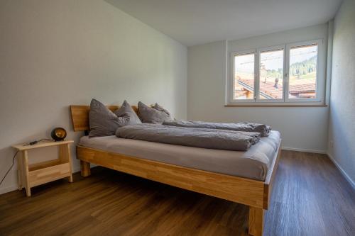 阿德尔博登Chuenislodge1 Neu, grosse Terrasse & Designerofen, prächtige Aussicht的窗户客房内的一张床位