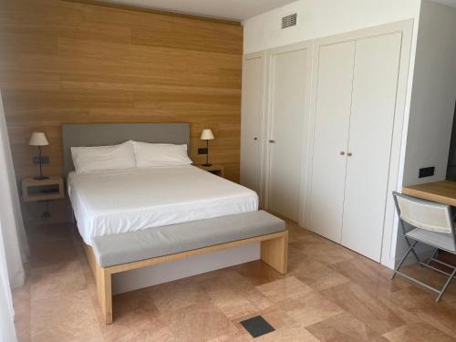 GualtaModerno apartamento en Empordà Golf的一间小卧室,配有一张床和一把椅子