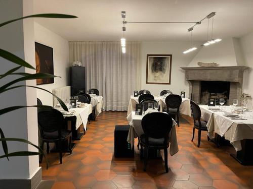 卡斯泰洛城Agriturismo Villa Paradiso Esotico的一间设有白色桌椅和壁炉的用餐室