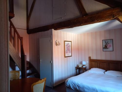 欧苏瓦地区瑟米Hôtel des Cymaises的一间卧室设有一张床、一个楼梯和一张桌子