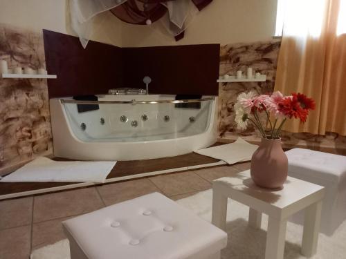 贾迪尼-纳克索斯Villa Laura Apartment的带浴缸和花瓶的浴室
