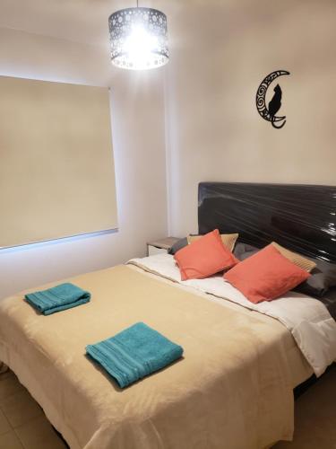 卢汉德库约La Casita de Lujan的一间卧室配有一张床,上面有两条毛巾