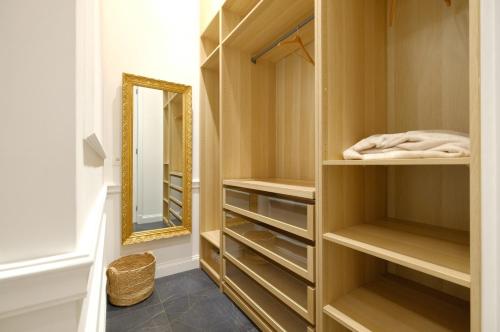 蒙斯Suite la Duchesse et Parking privé gratuit的更衣室设有木制橱柜和镜子