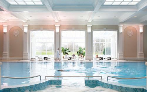 亨洛钱普尼斯亨洛酒店的大型客房的游泳池,设有大窗户