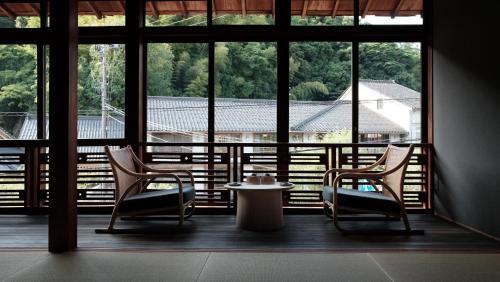 丰冈市Kobayashiya -Kinosaki Onsen-的带窗户的客房内配有两把椅子和一张桌子