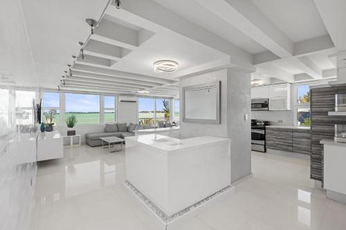 圣胡安Amapola SeaSide Beach Front Apartment的一间白色的大厨房和带水槽的客厅