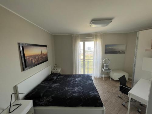 米兰SKYLINE MILANO Fiera的一间卧室配有一张床、一张书桌和一个窗户。