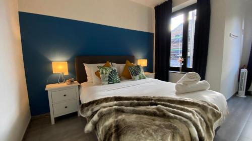 安特卫普Oneluxstay Antwerp City Centre的一间卧室设有一张蓝色墙壁的大床
