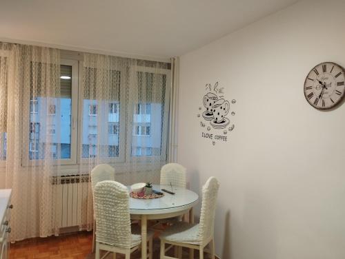 萨拉热窝Apartman F&S - Novo Sarajevo的一间带桌椅和时钟的用餐室