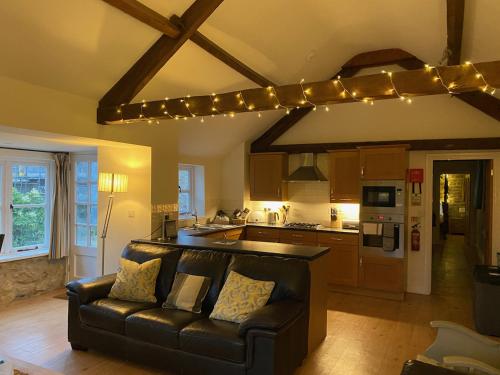 布里德波特Norburton Hall Cottages的带沙发的客厅和带灯的厨房