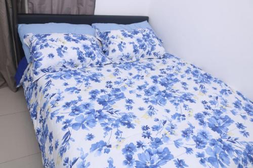 JarbangKoring Residence at Dalaba Estate的一张带蓝色和白色棉被和枕头的床