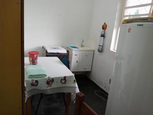 卡尚布Hostel Cantinho da Paz的白色的小厨房,配有桌子和窗户