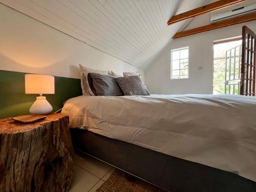 哈博罗内Cosy City Cottage的一间卧室配有一张床和一张带台灯的桌子