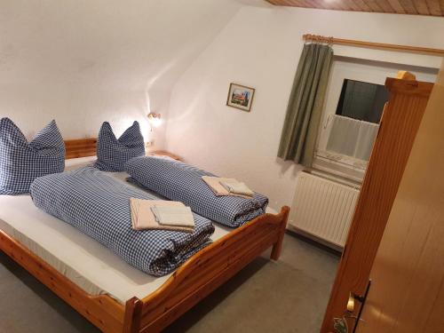 布罗特罗德Ferienhaus am Rennsteig-Pension zur Wetterwarte的一间卧室配有两张带蓝白色枕头的床