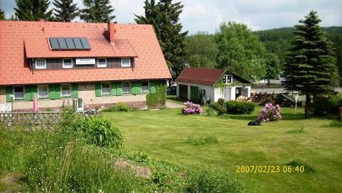 布罗特罗德Ferienhaus am Rennsteig-Pension zur Wetterwarte的一座房子,在院子里设有太阳能屋顶
