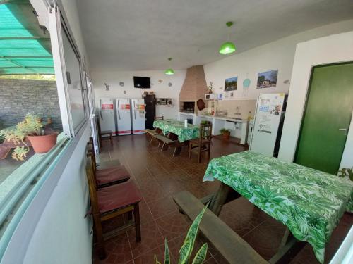 坦季Hostal El Trébol - Tanti的一间带桌椅的用餐室和一间厨房
