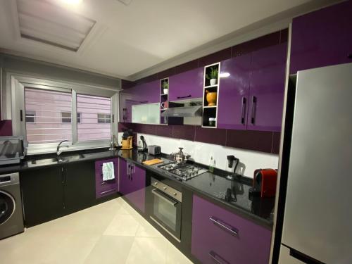 得土安Riverside Tétouan的紫色的厨房配有水槽和炉灶