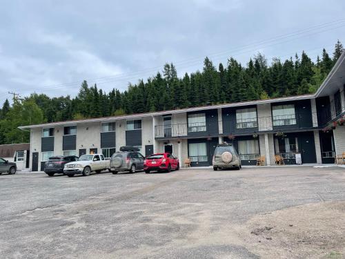 贝科莫Motel du rosier的停车场内有车辆的建筑物