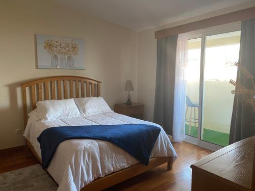 Água de AltoMountain and Ocean View的一间卧室设有一张床和一个滑动玻璃门
