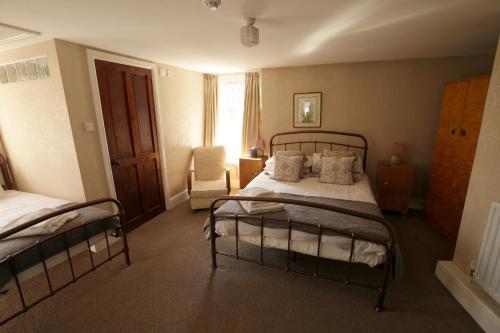 WhittingtonFitzwarine House Whittington的一间卧室配有两张双层床和椅子