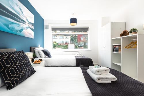 南安普敦3 Bedrooms house ideal for long Stays!的一间卧室设有两张床和蓝色的墙壁