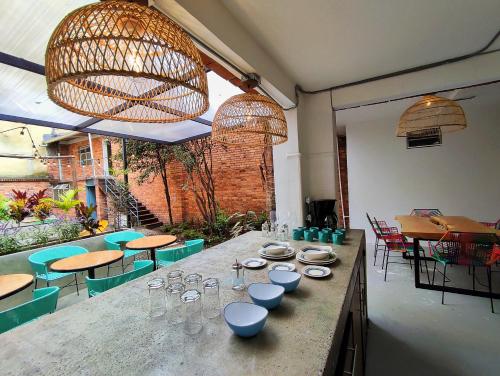 波哥大Trip Monkey Chapinero的餐厅设有桌子,上面有盘子和玻璃杯