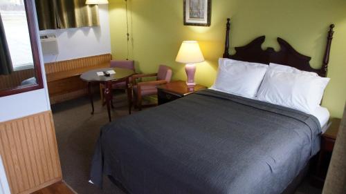 彼得伯勒罗布恩汽车旅馆的酒店客房,配有一张床、一张桌子和椅子