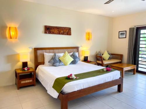 维拉港纳萨马度假酒店的一间卧室配有一张带鲜花的大床
