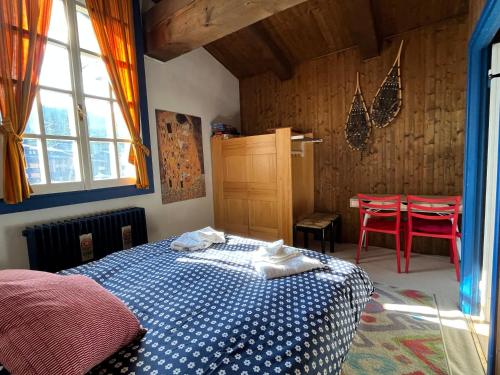 摩德纳迪-坎皮格里奥Tuckett Lodge - A large flat for families and groups of friends的一间卧室配有一张床和一张桌子及红色椅子