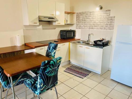 帕皮提Studio Papeete Lodge - Kaoha Nui的厨房配有桌子、水槽和冰箱