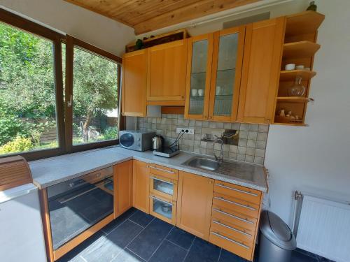 米什科尔茨Hámori Álom的厨房配有木制橱柜、水槽和窗户。