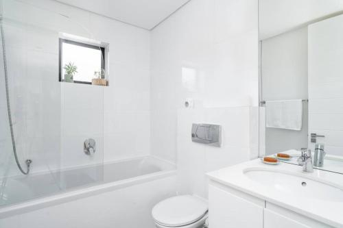 开普敦16 on Sloane的白色的浴室设有浴缸、卫生间和水槽。