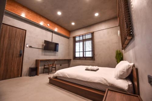 台南贰洋楼 的一间卧室配有一张床和一台平面电视