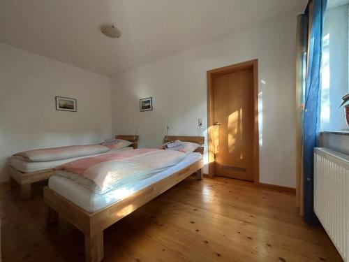 朗斯多夫迈耶饭店的一间卧室设有两张床,铺有木地板