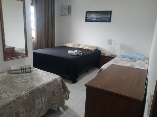里约热内卢Buganville House Cabo Frio的酒店客房设有两张床和一张桌子。