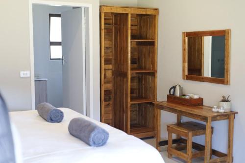 贝拉贝拉Waterberg Game Lodge的一间卧室配有两张床、一张桌子和一面镜子