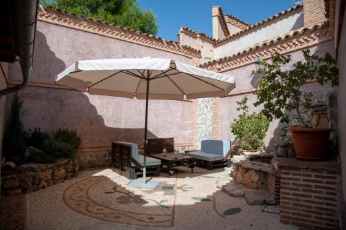 Colmenar de OrejaLa Encomienda de Oreja的庭院配有桌椅和遮阳伞。