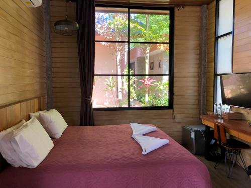 班佩Likita Resort的一间卧室配有一张床、一张书桌和一个窗户。