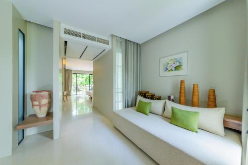 Khao YaiSiamdasada Khaoyai的客厅配有白色沙发和绿色枕头。