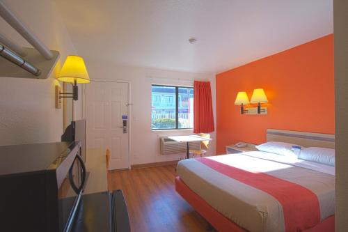 查尔斯顿North Charleston Lodge的酒店客房,配有一张橙色墙壁的床
