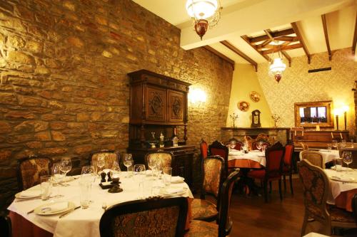 SklíthronGuesthouse Agonari的一间带桌椅和石墙的餐厅
