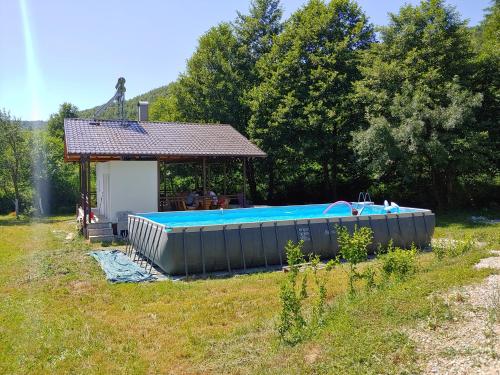 比哈奇Kuća u šumi - Forest house near National park Una - Air Spa Lohovo的凉亭前的大型游泳池