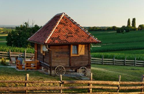 StarčevljaniTiny house AMBAR的围栏旁田野的小房子